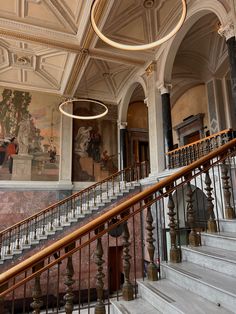 an ornately decorated staircase in a building with paintings on the walls and flooring