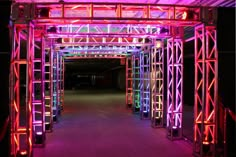 an illuminated tunnel with many colorful lights on the walls and floor, along with multiple columns