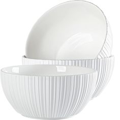 the white dishes are stacked on top of each other, and have pleated design