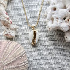 We love this fun and summery, beachy necklace. Answer the siren's song and get one for yourself or someone you love. Would make a great gift for the surfer or beach-lover in your life! A 14k gold electroplated cowrie shell dangles from a lustrous, high quality gold filled snake chain. The perfect summertime accessory! Chain length 16"✦ JEWELRY CARE ✦✧ Warm water and a soft cloth are the best thing you can do to maintain the beauty of your jewelry.✧ Jewelry polishing cloths work great and are non Gold Starfish Charm Necklace For Beach Season, Gold Necklace With Starfish Charm For Beach Season, Gold Charms Jewelry For Vacation, Gold Vacation Jewelry With Charms, Vacation Gold Jewelry With Charms, Beach Jewelry With Charms In Ocean-inspired Style, Gold Shell Necklace With Starfish Charm For Beach, Beachy Shell Jewelry For Festivals, Beachy Shell Jewelry For Festival