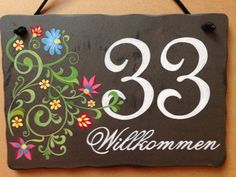 a sign hanging on the side of a wall that says 33 millommen with flowers