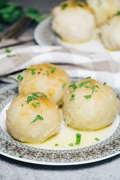 three rolls on a plate with sauce and parsley