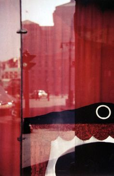 a black chair sitting in front of a red curtain