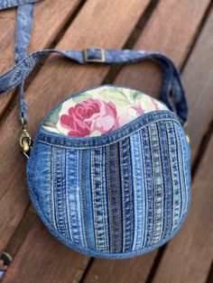 a blue jean purse sitting on top of a wooden bench