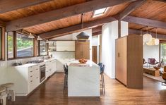 an open kitchen and living room with wooden ceilings