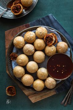 some food is sitting on a plate with dipping sauce