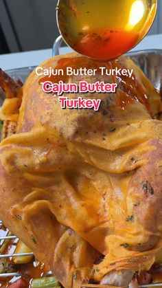 there is a turkey covered in sauce on top of a rack with the words cajun butter turkey above it