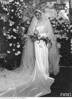 an old black and white photo of a woman in a wedding dress