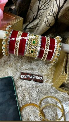 several different types of bracelets on display next to a cell phone and other accessories