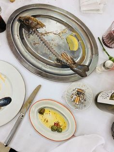 an empty plate with food on it next to other plates and utensils sitting on a table