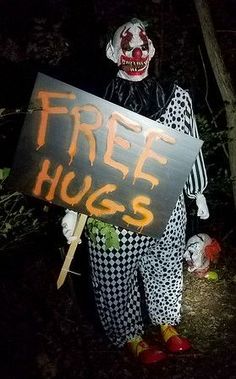 a creepy clown holding a free hugs sign