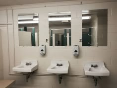 three sinks and mirrors in a public restroom