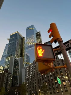 a traffic light that is red and yellow in front of some tall buildings at night