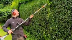 a man is using a hedge trimming machine