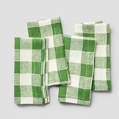 four green and white checkered napkins sitting on top of each other