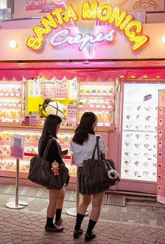 two girls standing in front of a candy store