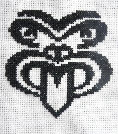 the cross stitch design is black and white, with an ornate heart on it's side