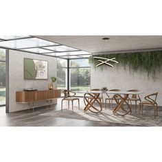 a dining room with a table and chairs next to a wall covered in greenery