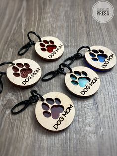 four personalized dog tags with paw prints on them