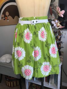 "Cute as can be! Apple green with whimsical flowers in white and neon pink. Attached white cotton and lace petticoat. Two tiny Frey's in fabric at the hem pictured. Easily repaired. Measurements: 26\" waist 42\" free flared hips 70\" circumference at hem 1-3/4\" waistband 7-1/2\" back nylon zipper with two button waist closure 19\" from top of the waistband to hem from the back" Cute Cotton Skirt With Floral Print, Spring Green Cotton Skirt, Green Cotton Skirt For Spring, Green Skirt For Spring Garden Party, Green Skirt For Daywear, Green Bottoms For Summer Garden Party, Green Retro Skirt For Summer, Retro Green Skirt For Summer, Spring Vintage Skirted Bottoms