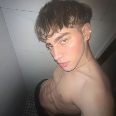 a young man with no shirt on in the bathroom