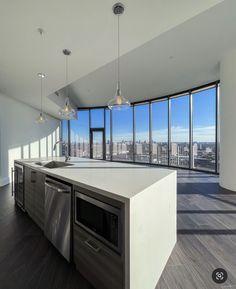 an empty kitchen with lots of windows overlooking the cityscape in this modern apartment