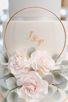 a wedding cake with white frosting and pink flowers