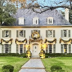 a large white house decorated for christmas with wreaths and lights