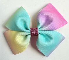 Reilly Rainbow Designs creates handmade hair bows, to help your child always feel confident and fashionable at the same time. This beautiful bow is created with Grosgrain ribbon and either an alligator hair clip or a nylon headband.  These bows measure approximately 3.5". Each bow is packaged on a bow card and shipped in a bubble envelop to protect each item during transit. All orders ship within 1-2 business days of purchase via USPS. Please note, this is NOT transit time, as I am not responsib Rainbow Pastel Hair Bows, Pink Glitter Hair Bow, Handmade Hair Bows, Pastel Hair, Rainbow Design, Hair Accessories Headbands, Grosgrain Ribbon, Baby Headbands, Hair Bows