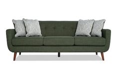 a green couch with four pillows on it