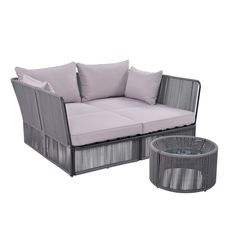 an outdoor sofa and coffee table with pillows