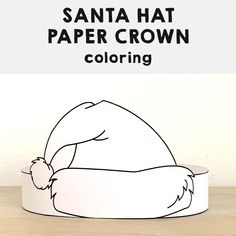 the santa hat paper crown is sitting on top of a table with text overlaying it