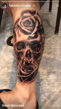 a man's leg with a skull and rose tattoo on it