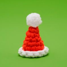 a red and white knitted santa hat on a green background