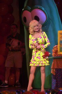 a woman in a yellow dress standing on stage