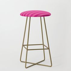 a pink and gold bar stool with a striped seat cushion on the bottom, in front of a white background