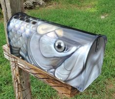 a metal mailbox sitting on top of a wooden post