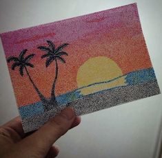 someone is holding up a card with a sunset and palm trees on it