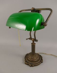 Introducing the Antique Brass Banker's Desk Lamp with Green Glass Shade, a timeless piece that exudes elegance and sophistication. This exquisite desk lamp showcases a beautiful brass finish, giving it a touch of vintage charm and character. Crafted with attention to detail, it features a stunning green glass shade that provides a soft and subtle glow, perfect for creating a warm and inviting ambiance in any space. Measuring at a convenient size, this lamp is 27 cm in length, 16 cm in width, and Weird Lamps, Bankers Desk Lamp, Lamp Office, Apt Decor, Brass Desk Lamp, Baroque Decor, Diy Miniatures, Bankers Lamp, Brass Desk