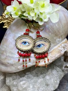 a close up of a piece of jewelry on a rock with flowers in the background