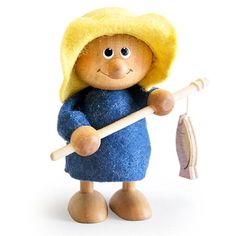 a wooden doll holding a fish and wearing a blue dress with a yellow hat on it's head