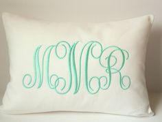 the monogrammed pillow is made with white linen and has green embroidery on it