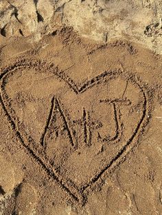 a heart - shaped sand drawing on the beach with words love and dad written in it