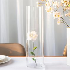 a vase with flowers in it sitting on a table next to a plate and fork