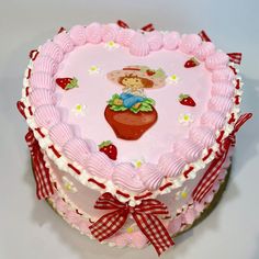 a pink heart shaped cake with a teddy bear on top