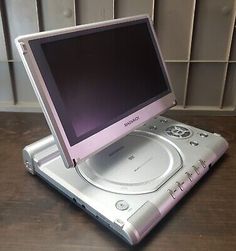 an open laptop computer sitting on top of a wooden table in front of a wall