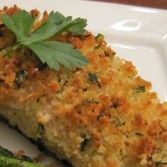 a piece of quiche on a white plate with green garnish and parsley