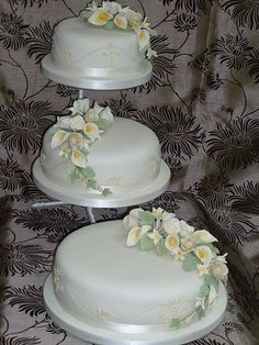 three white wedding cakes with flowers on them