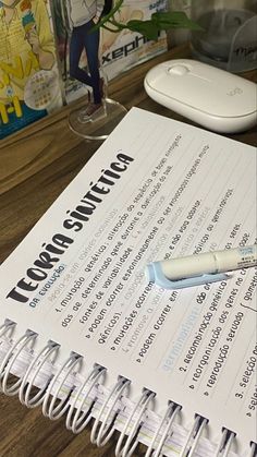 a close up of a book on a table with a pen and mouse next to it