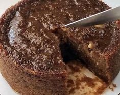 a piece of chocolate cake is being cut by a knife on a plate with a fork